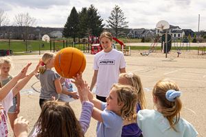 Exact Sciences Athlete Abby Wanezek speaks with kids playing basketball
